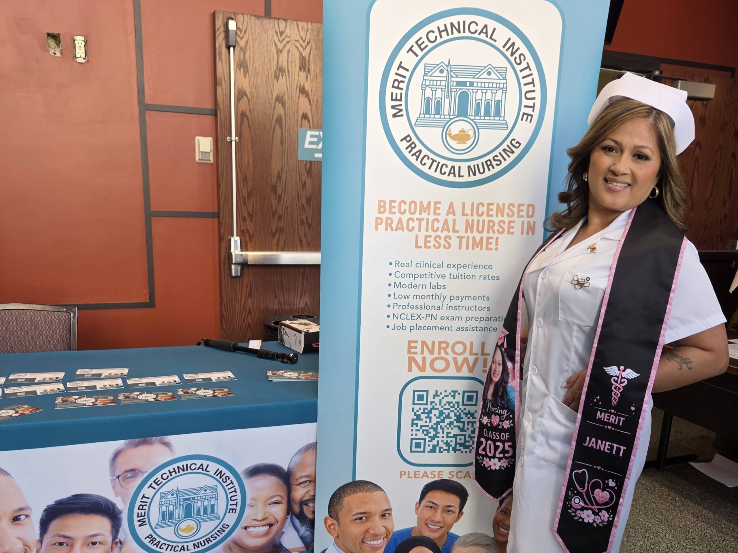 A woman in a white nursing uniform and graduation sash stands beside a Merit Technical Institute Practical Nursing enrollment banner.